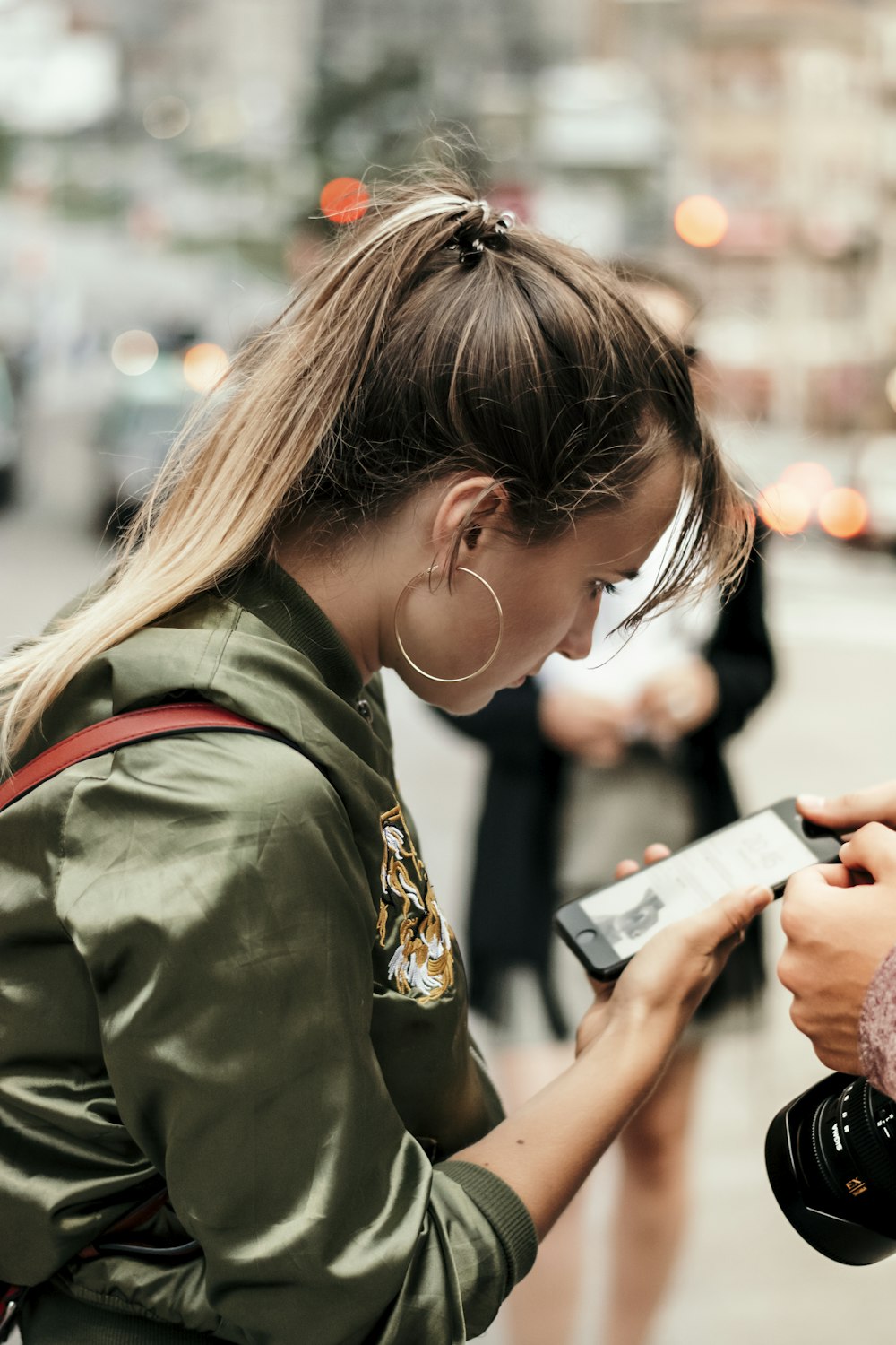 woman standing and staring on iPhone