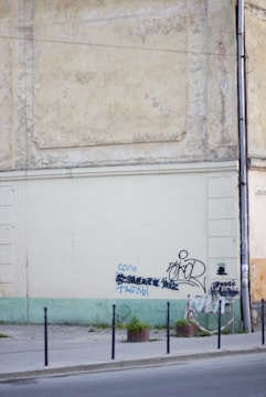 Before and after photos of graffiti removal from a city wall.