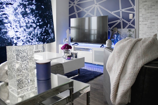 A modern living room with a stylish flat-screen TV mounted flawlessly on a dark accent wall.