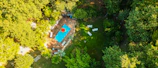 Aerial view of a newly remodeled pool surrounded by lush greenery and elegant deck.