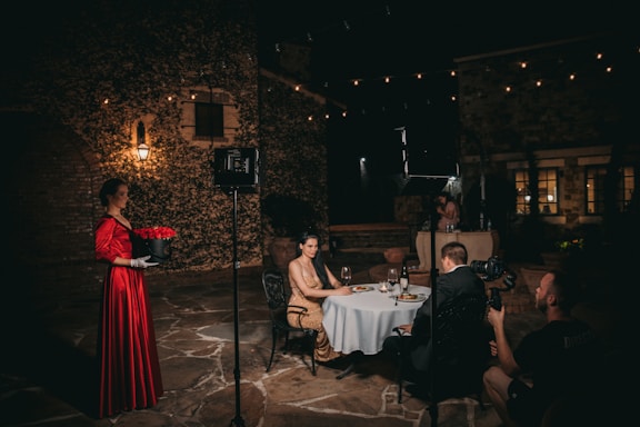 A cinematic shot of a filmmaker capturing a wedding scene in an elegant Italian villa at sunset.