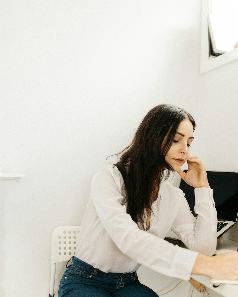 woman leaning on white table