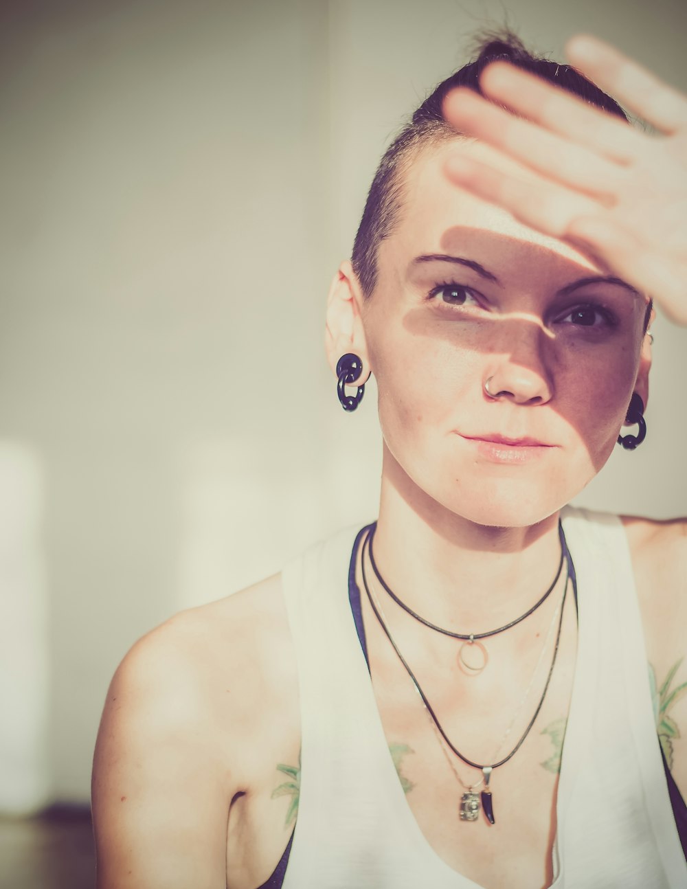 Frau in weißem Tanktop, das die Sonnenwärme abdeckt