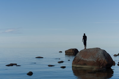 man standing on brown rock