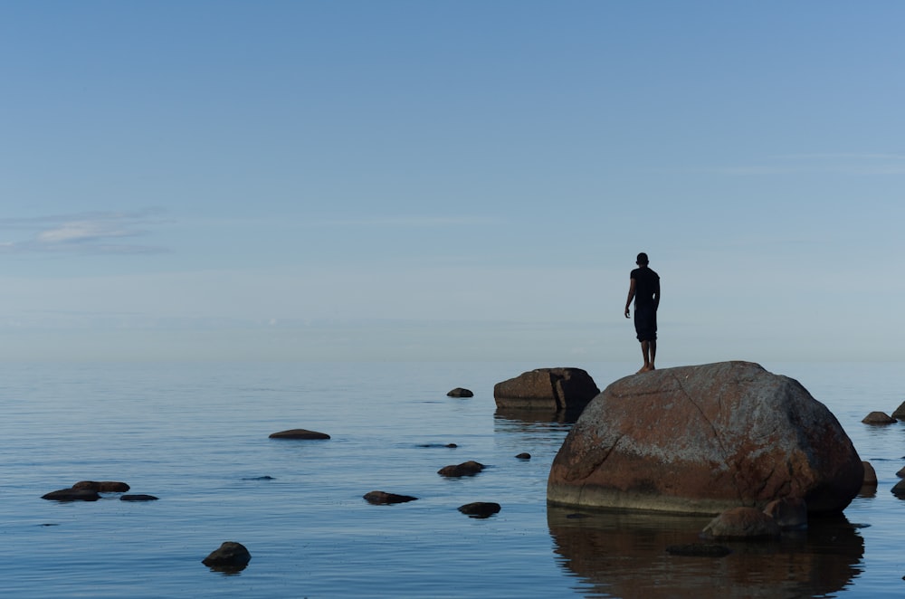 man standing on brown rock