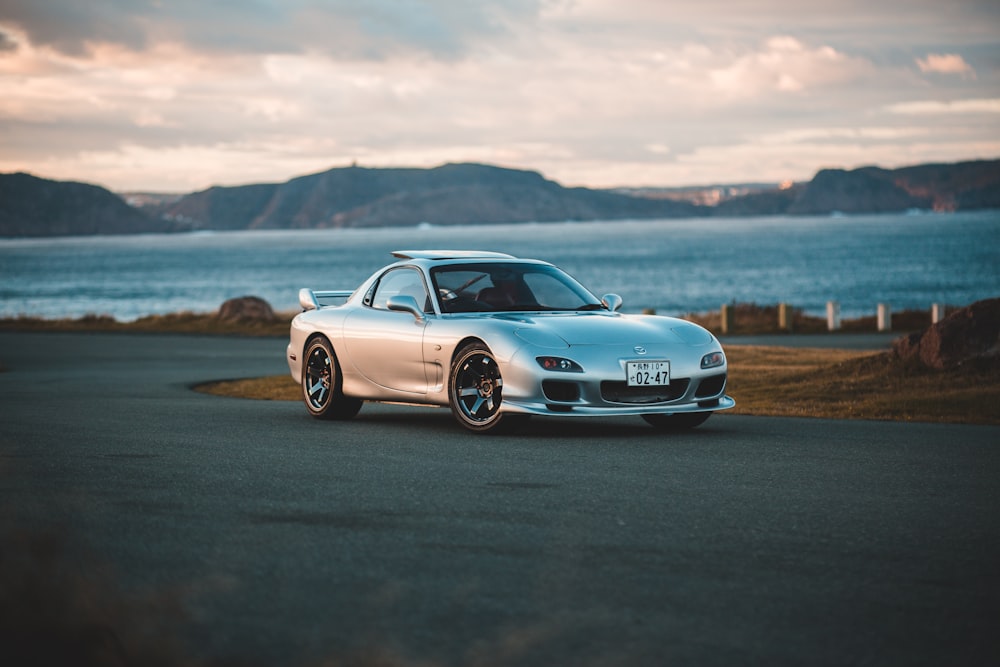 gray coupe near body of water