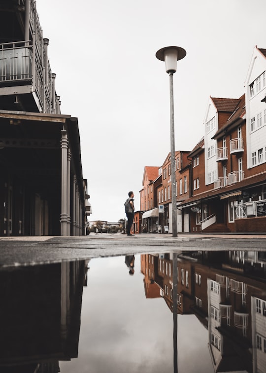 low-angle photography of man standing light post in Juist Germany