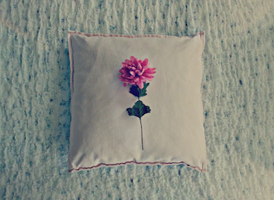 A plush cushion cover with a delicate floral pattern resting on a modern sofa.