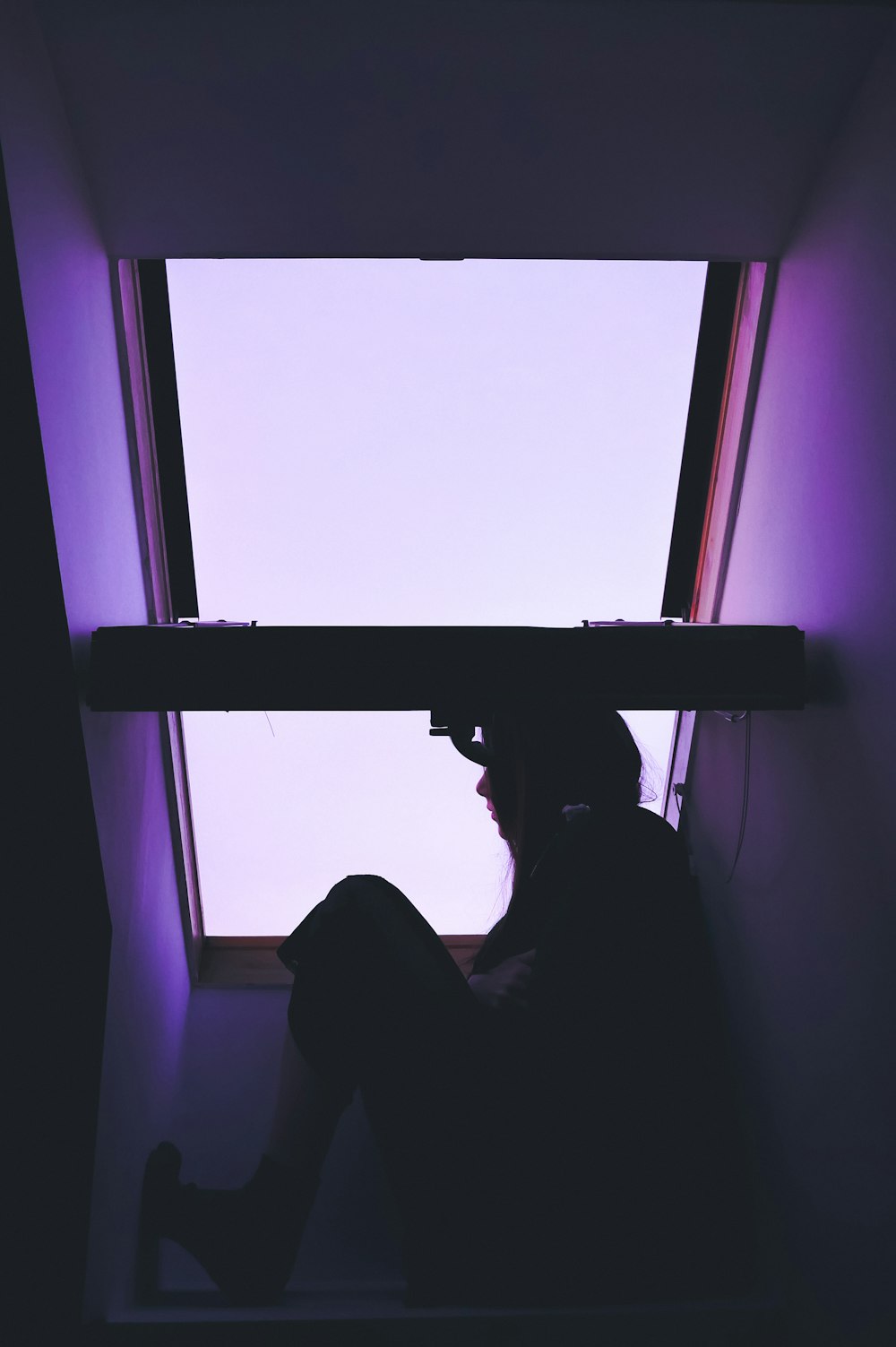 silhouette of person sitting near window