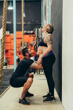 man squatting while touching woman's belly