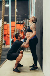 man squatting while touching woman's belly