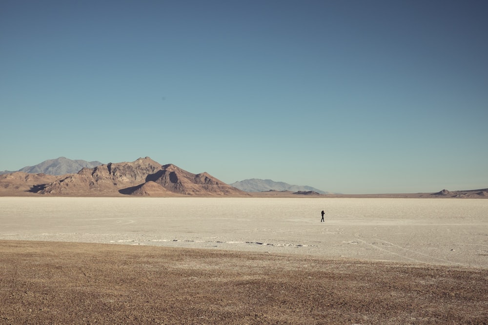 man walking in the middle of dessert