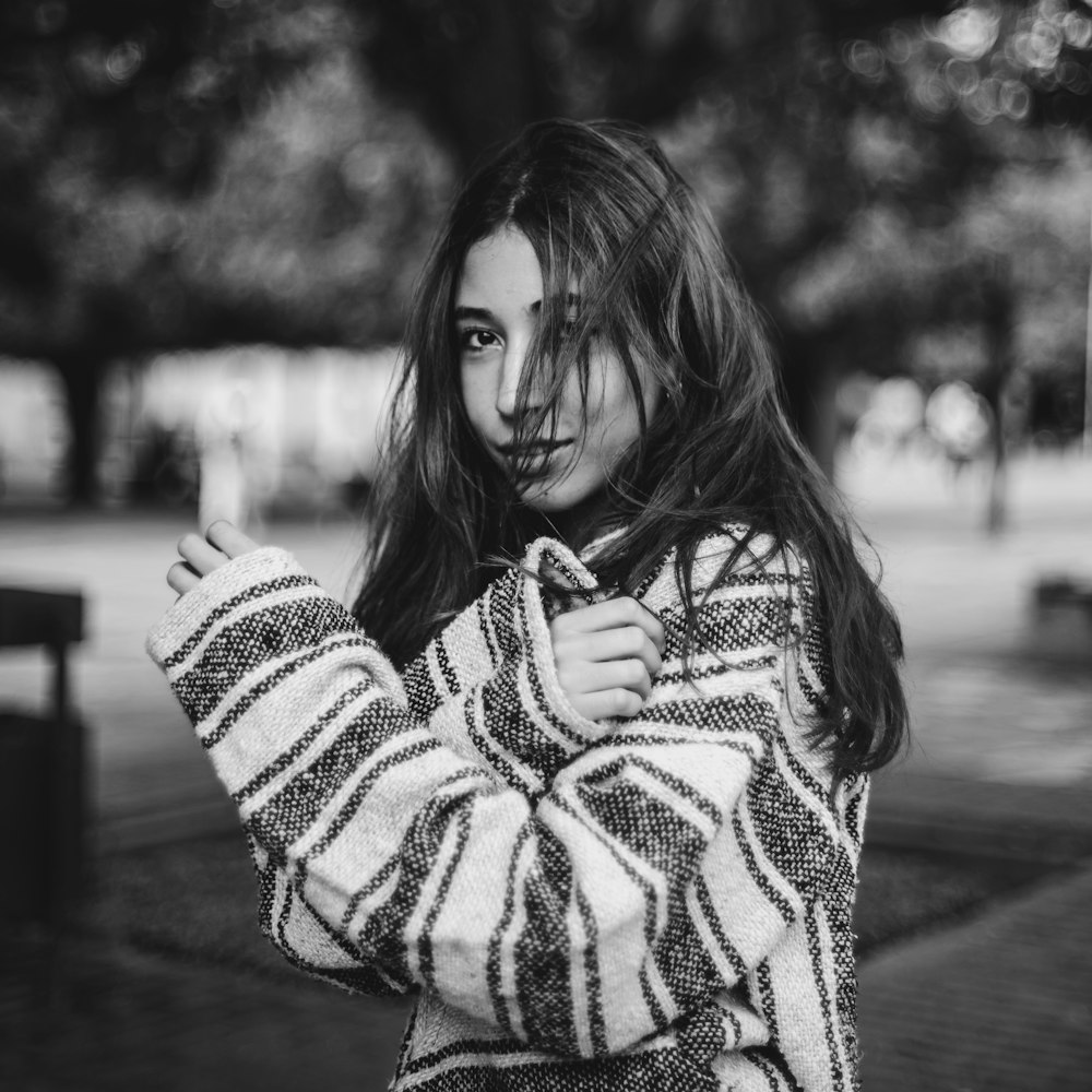 woman holding arm near tree