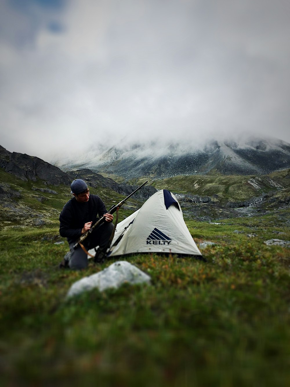 man sitting near camping tent