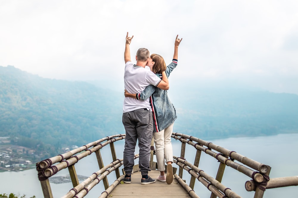 couple standing on brown wooden dock