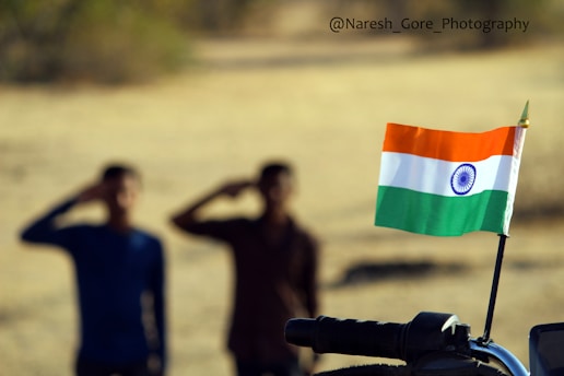 Handshake between business partners with USA and India flags in the background.