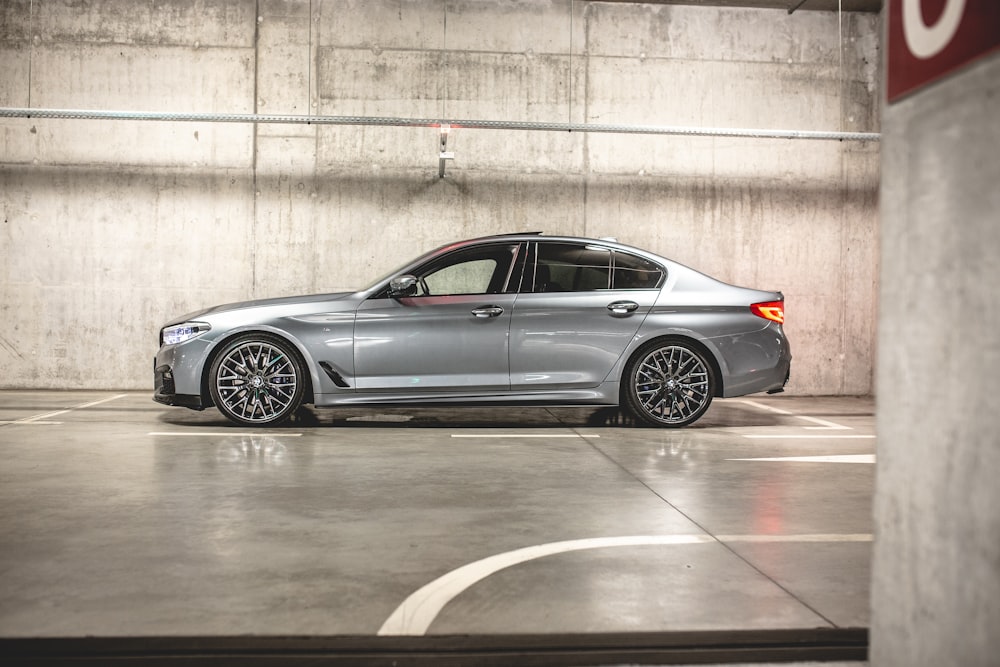 BMW berline grise sur place de parking