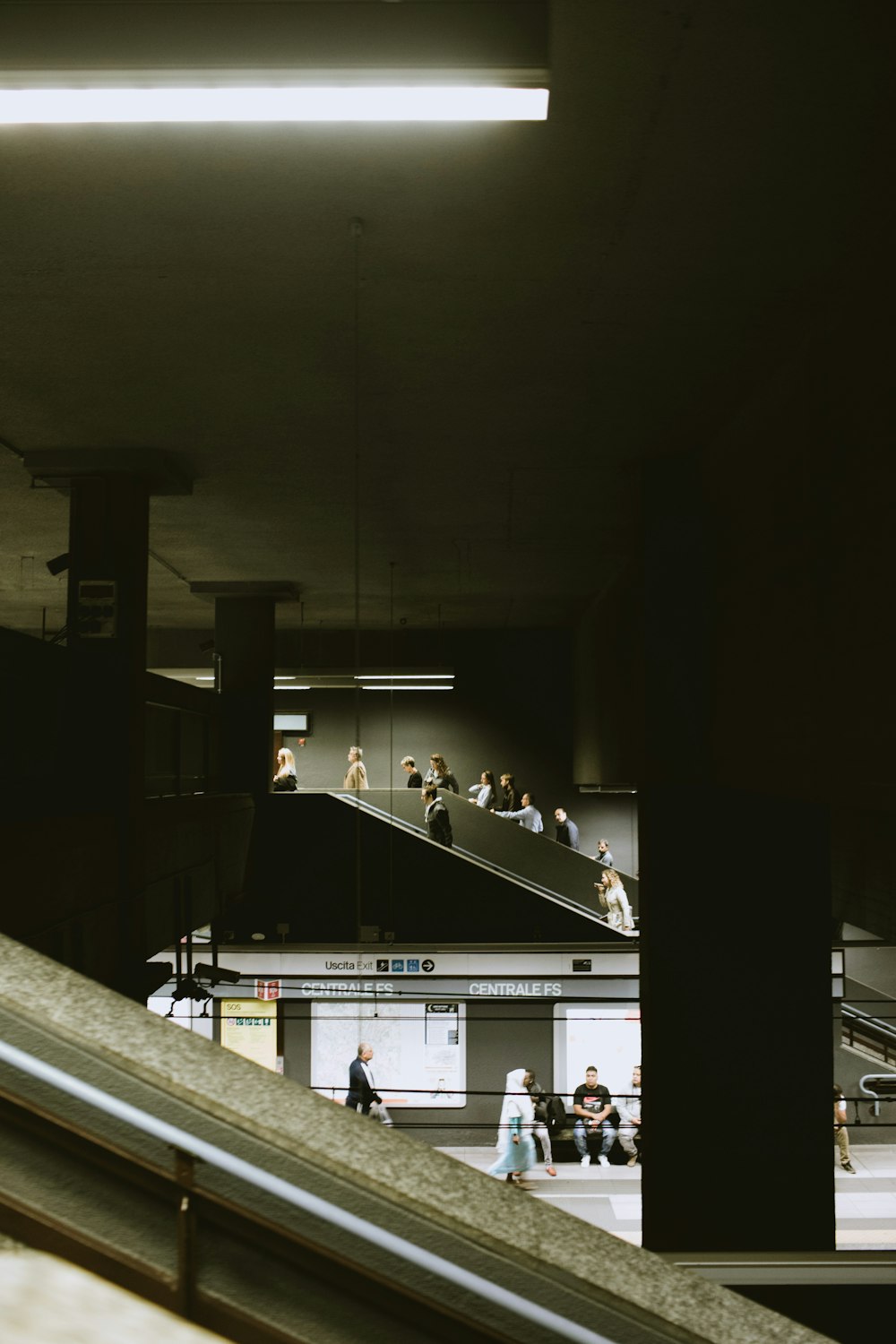 a group of people walking up and down an escalator