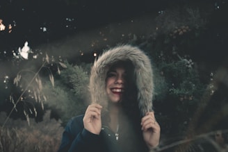 A happy customer wearing a cozy nmsd concepts hoodie, smiling in a sunlit urban park.