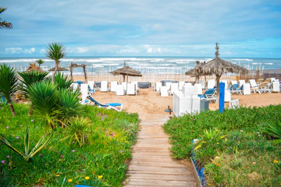 A peaceful pathway leading from the hotel to the private beach, framed by soft sand and gentle waves.