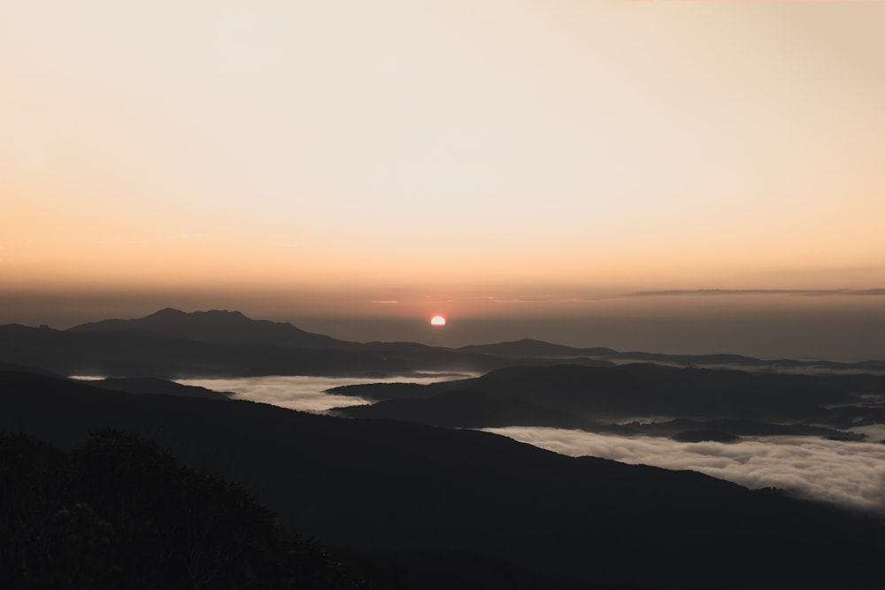 body of water near mountain during sunset