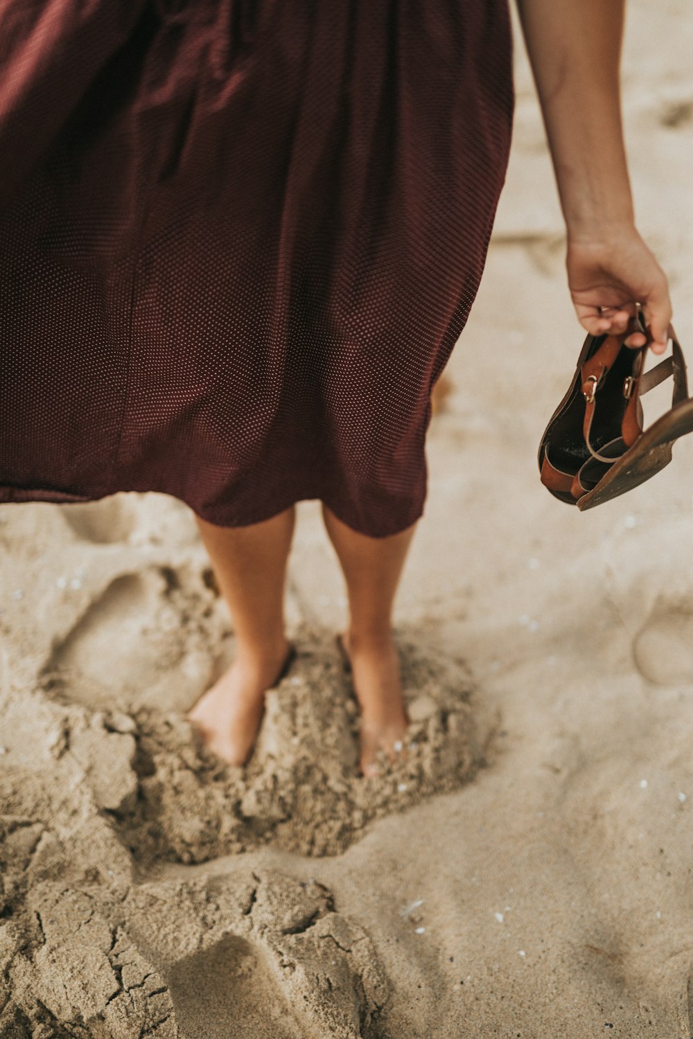 woman stepping on brown sand