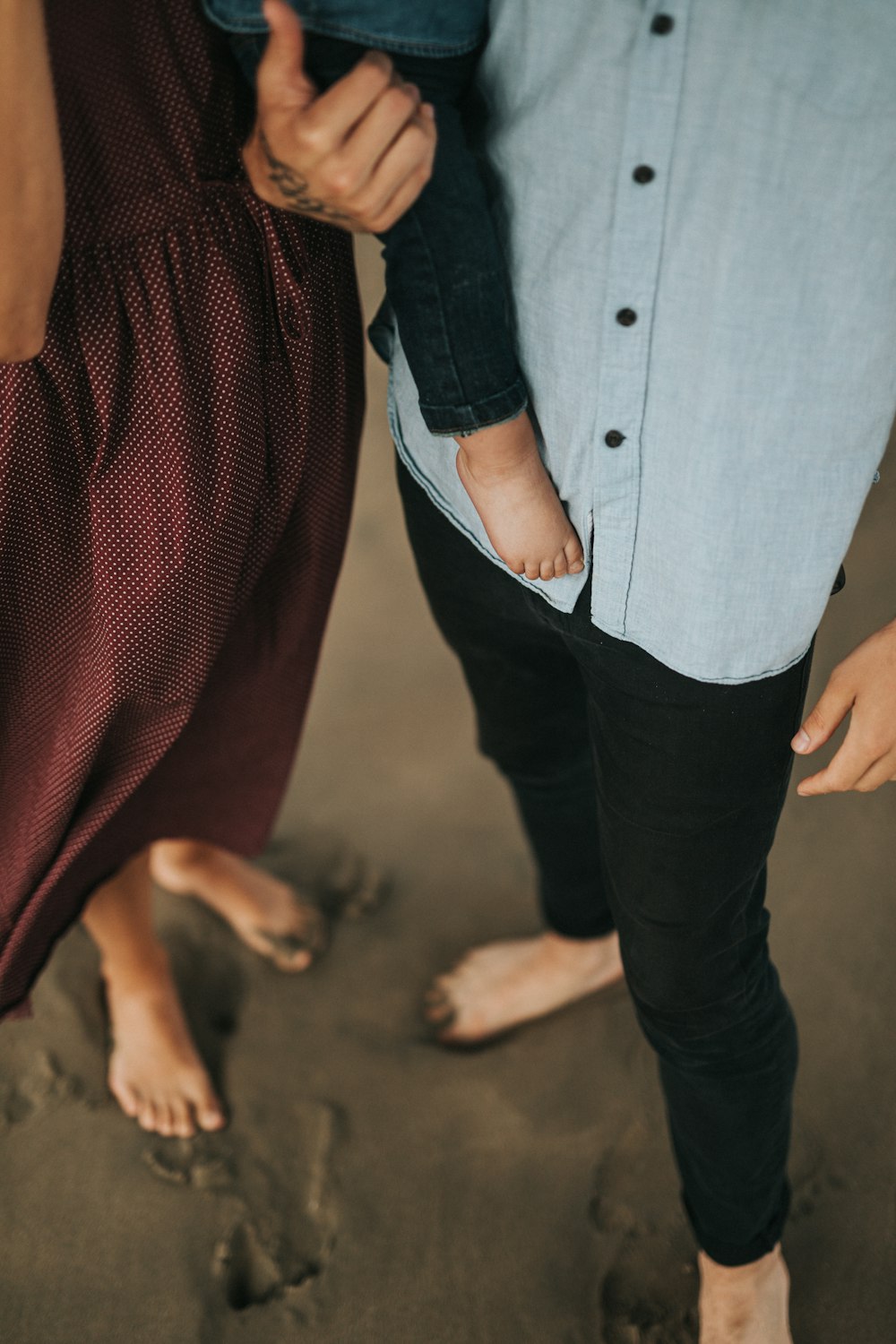 man and woman standing on black sand