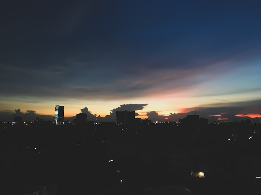 silhouette and aerial photography of city high rise building during golden hour