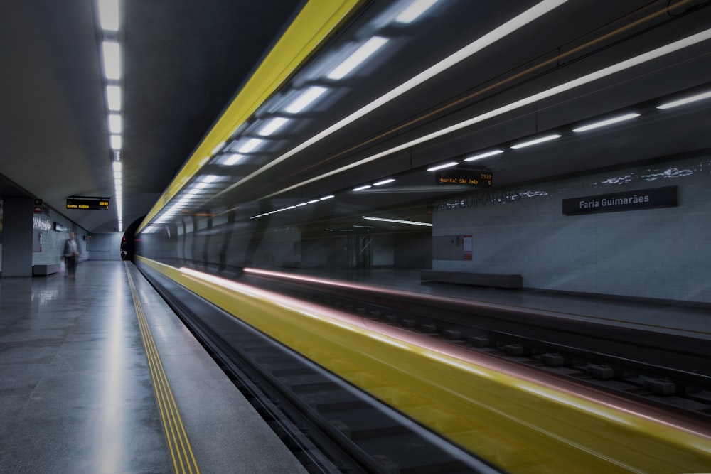 person standing near the train rails inside the tunnel