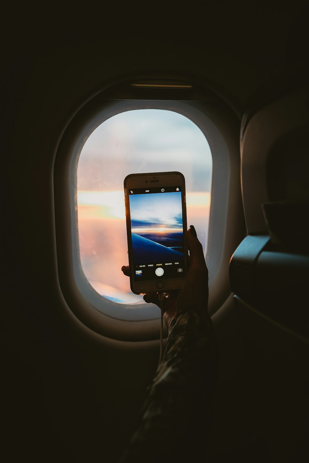 person taking picture of window plane
