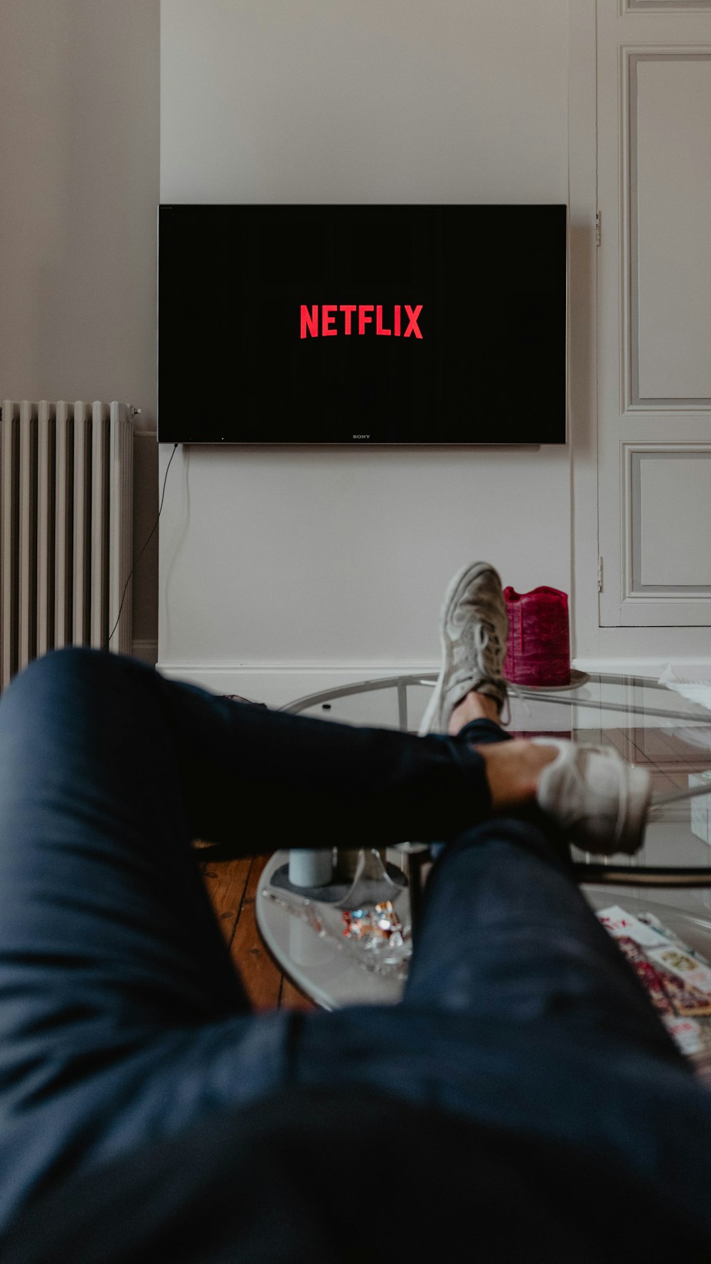 man lying on sofa infront of TV