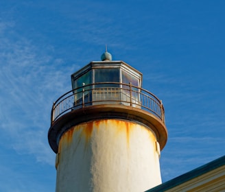 Close-up metal print of a weathered lighthouse with sunlight reflecting off the metal surface.