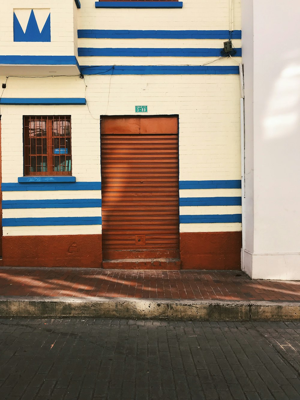 empty sidewalk beside closed brown door