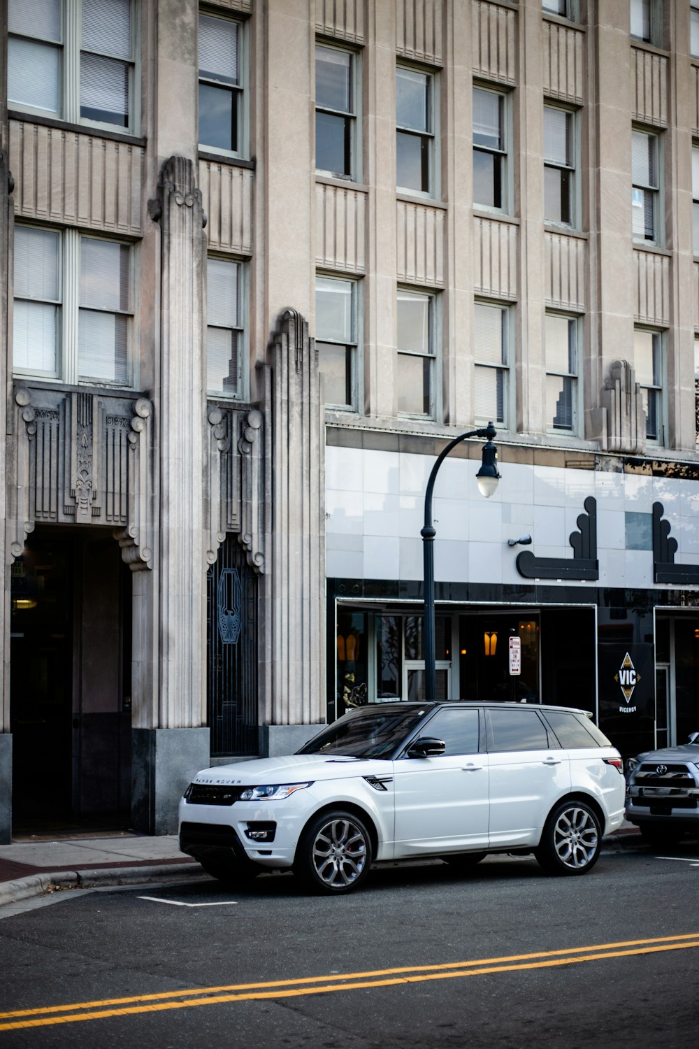 white Land Rover Range Rover SUV parked near buildin g