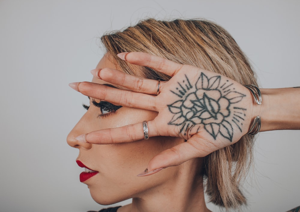 woman with black flower tattoo in palm