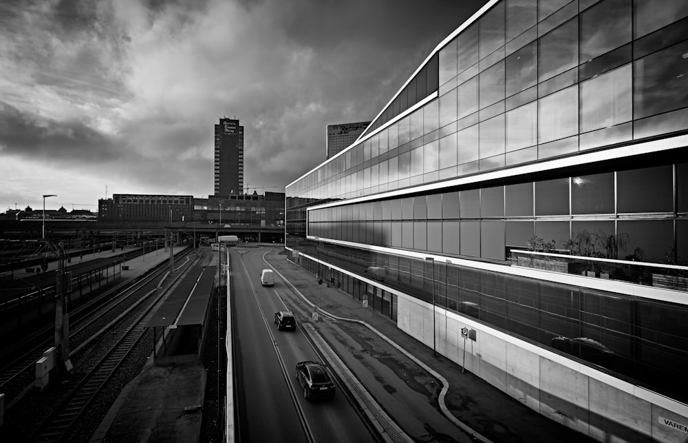 grayscale photo of vehicles crossing road during daytime