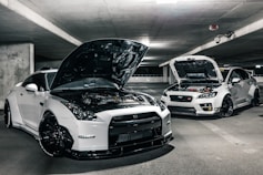 two white cars with open hoods