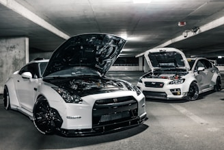 two white cars with open hoods