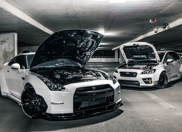 two white cars with open hoods