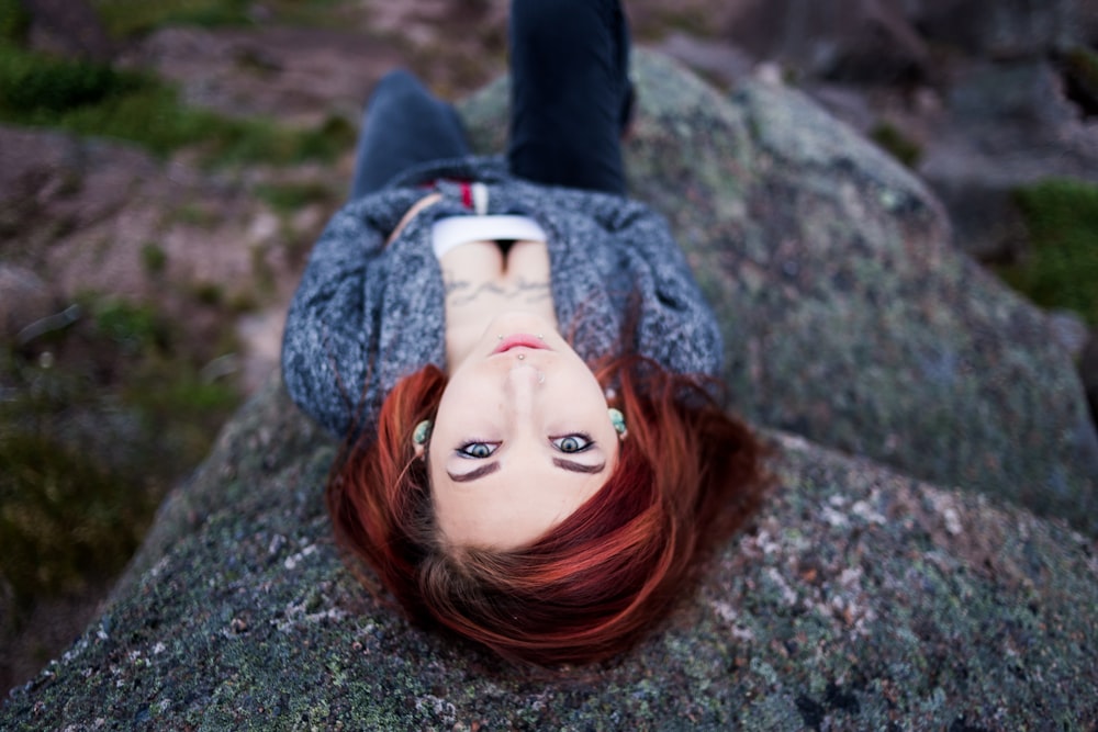 close-up photography of woman lying on rock at daytime