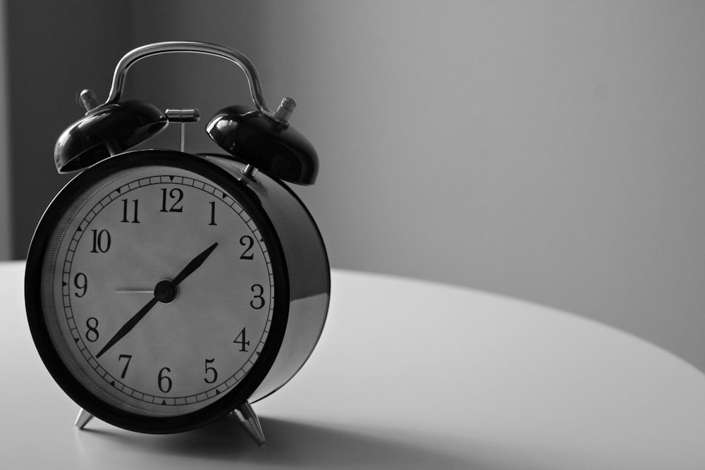 1:37 시간을 표시하는 알람 시계의 흑백 사진