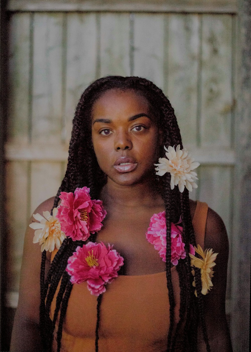 woman standing near white wall with multicolored flowers on her hair