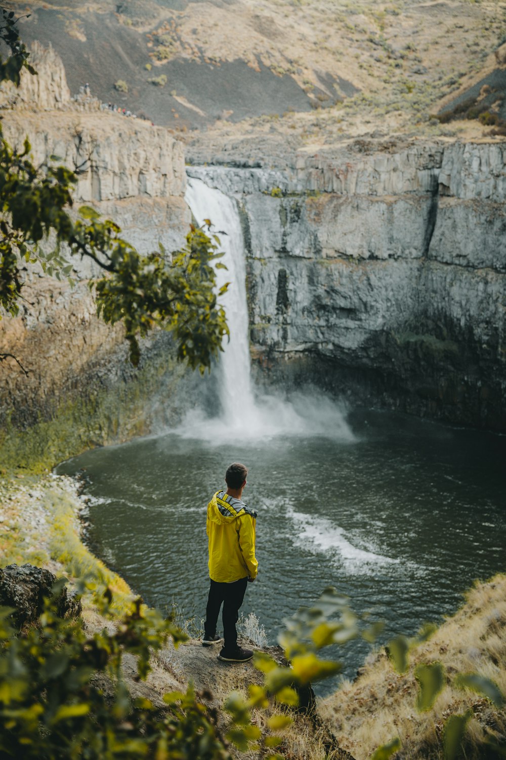 person standing near waterfall during daytime