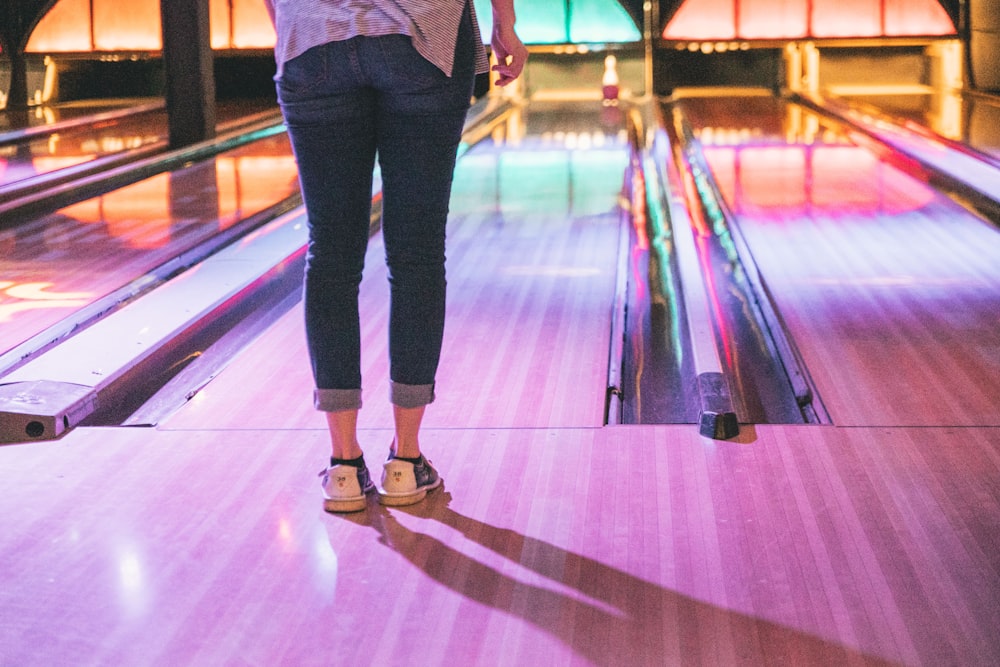 woman in blue jeans standing in front of bowling bay