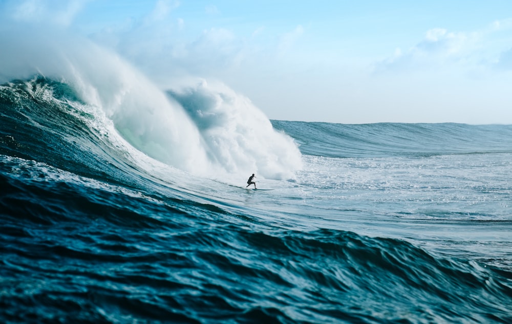 homme surfant vers les vagues de la mer