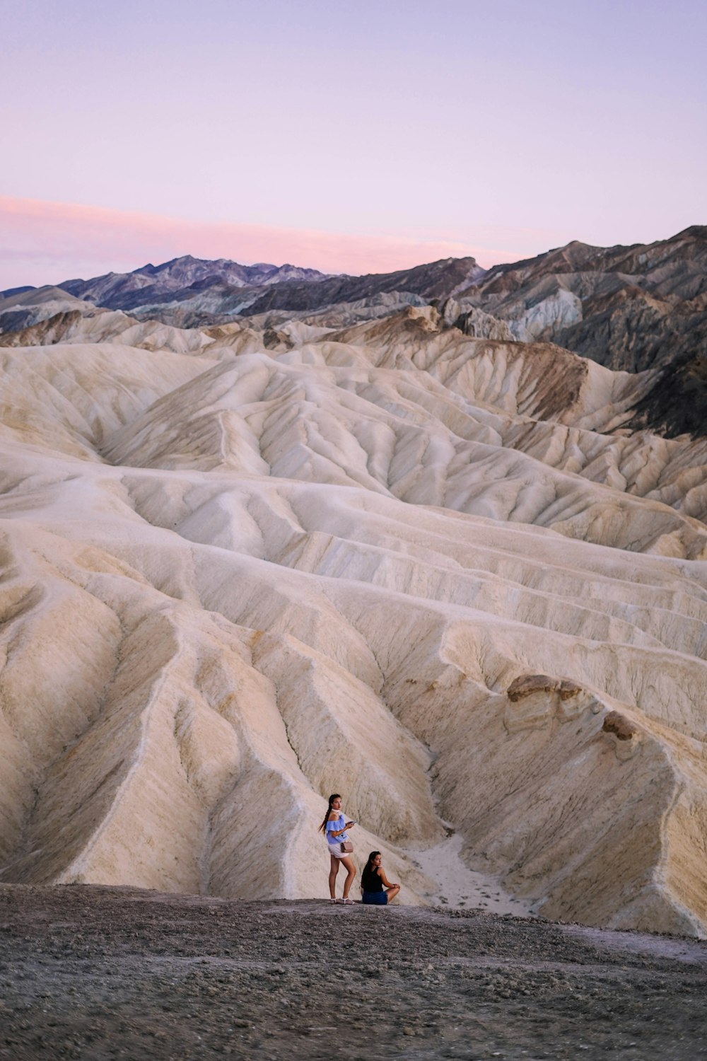 deux personnes debout près des dunes de sable