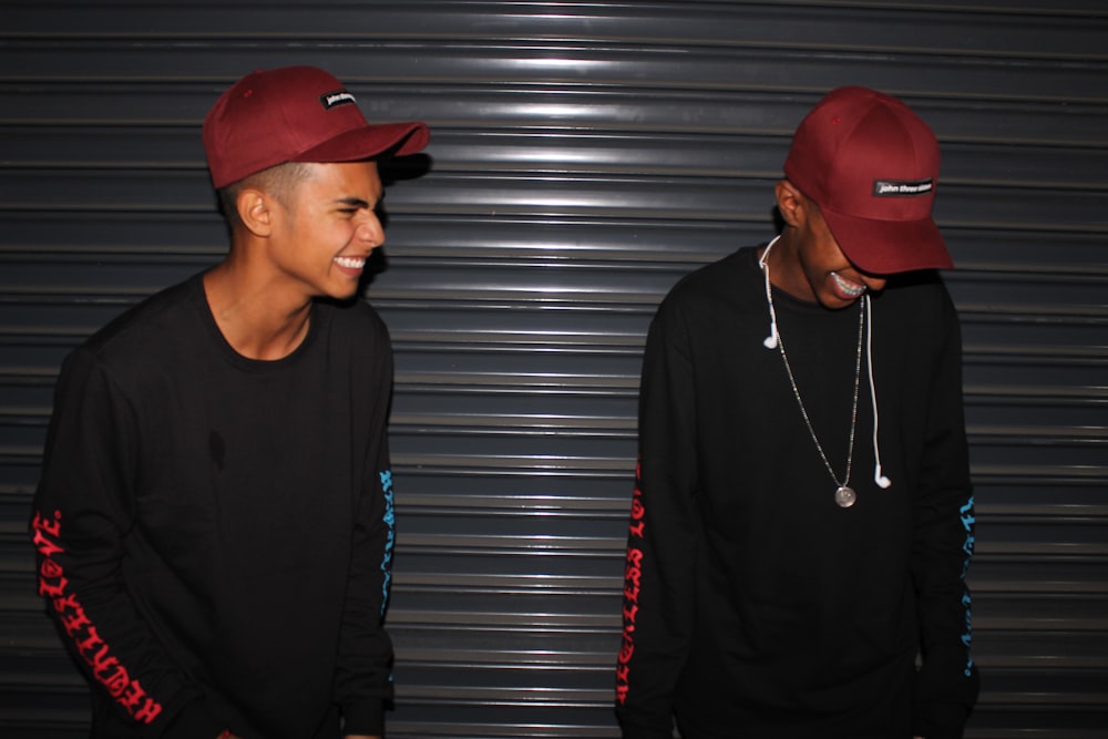 smiling two men standing front of door shutter