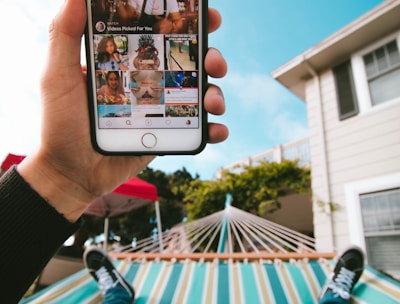 person on hammock using iPhone