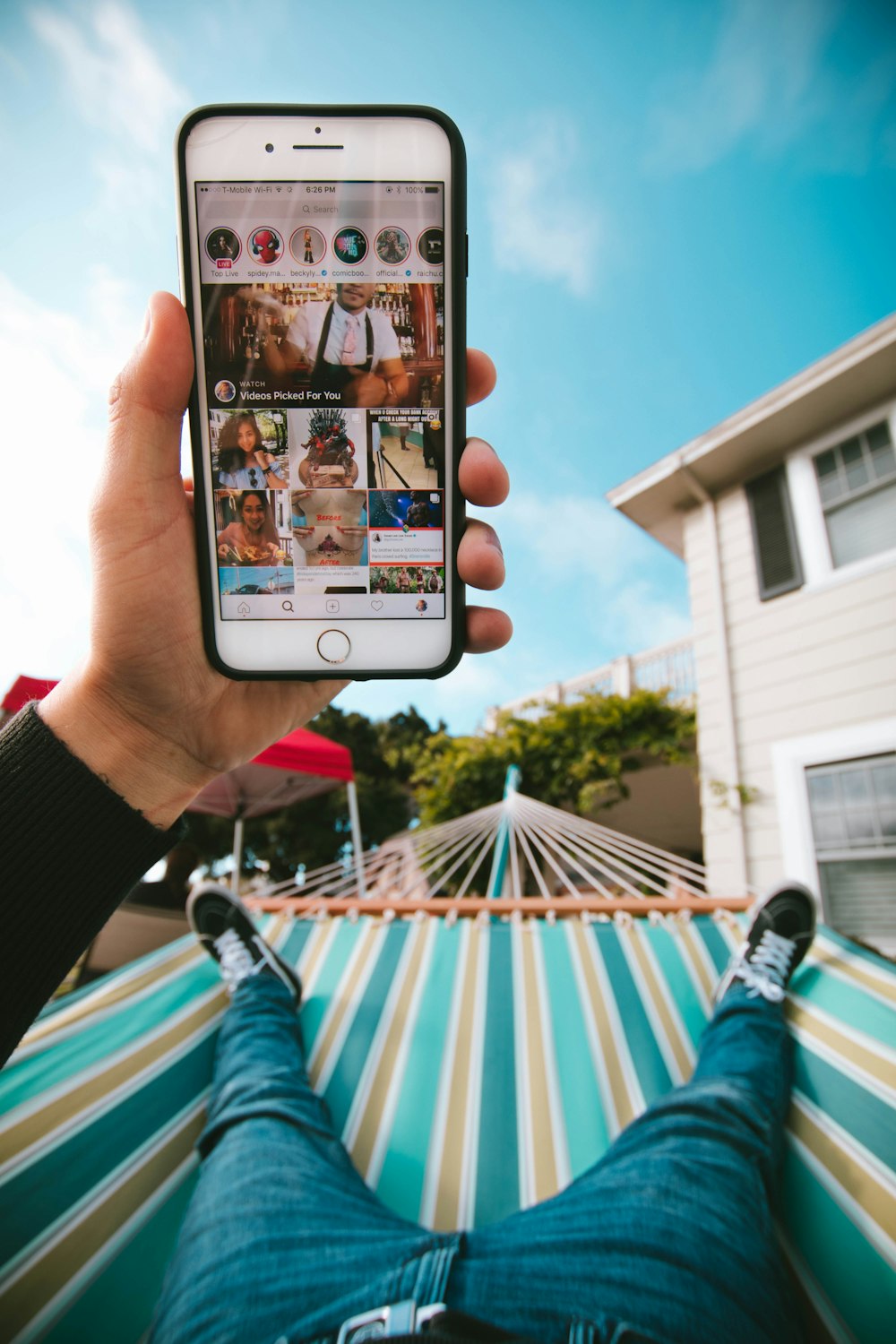 person on hammock using iPhone