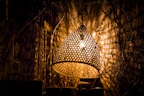Pastoral woven wall lamp adding texture and warmth to a quiet reading nook.